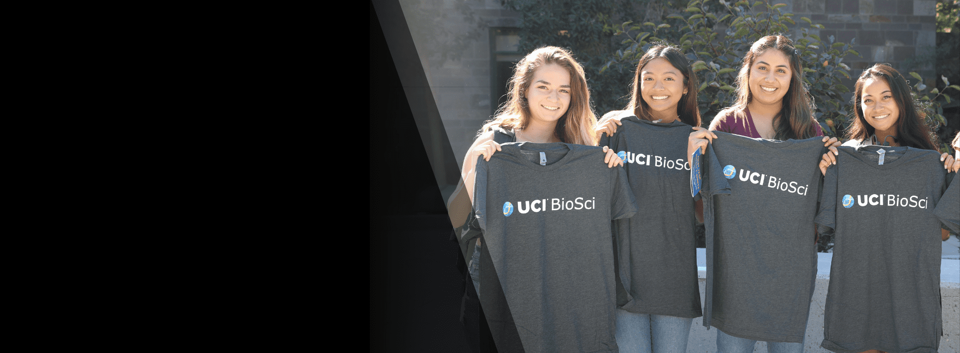 students holding up biosci shirts