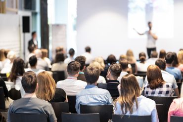 Business speaker giving a talk at business conference event.