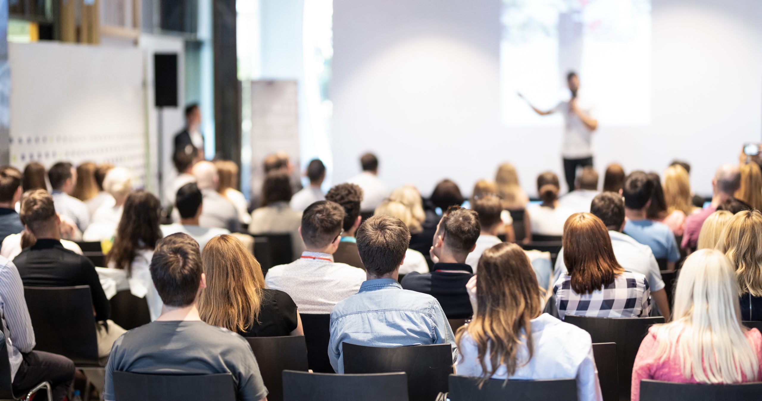 Business speaker giving a talk at business conference event.