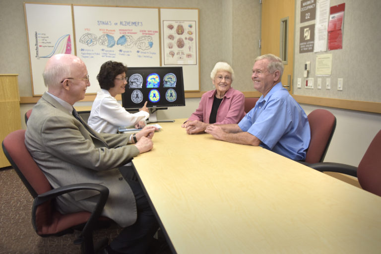 Alzheimers Patients speaking with specialists in an office
