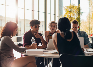 Group of students gathered at a table working on a project