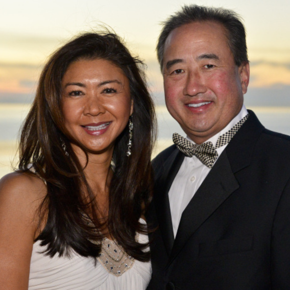 Portrait of Alumna Maggie Chang standing next to a man