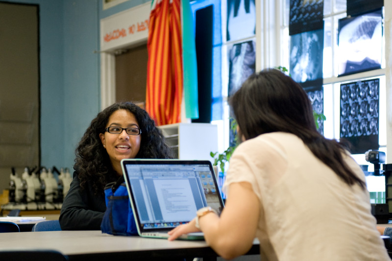 Photo of Crystal Calino and Stephanie Hsu in a classroom conversing with each other