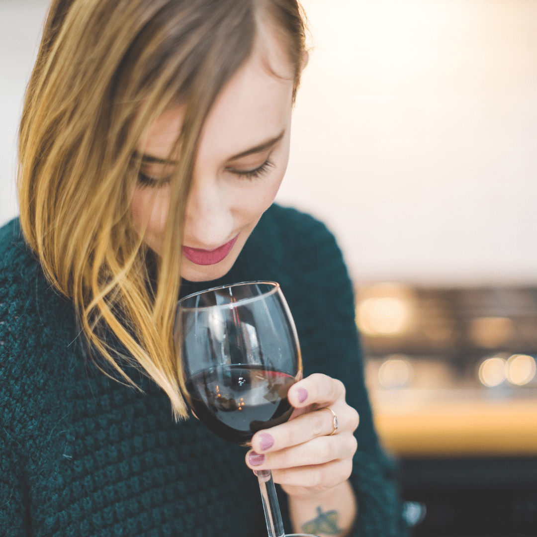 Photo of a woman drinking a glass of wine.