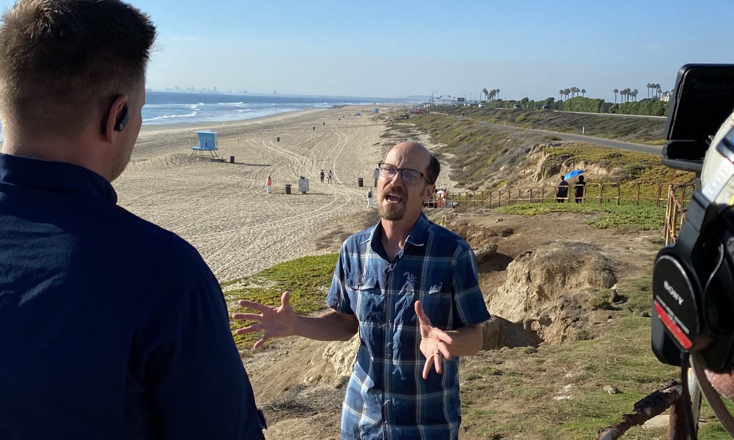 Reporter interviewing Dr. Matt Bracken at the beach