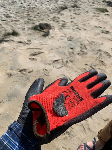 black tar on a red glove at the beach
